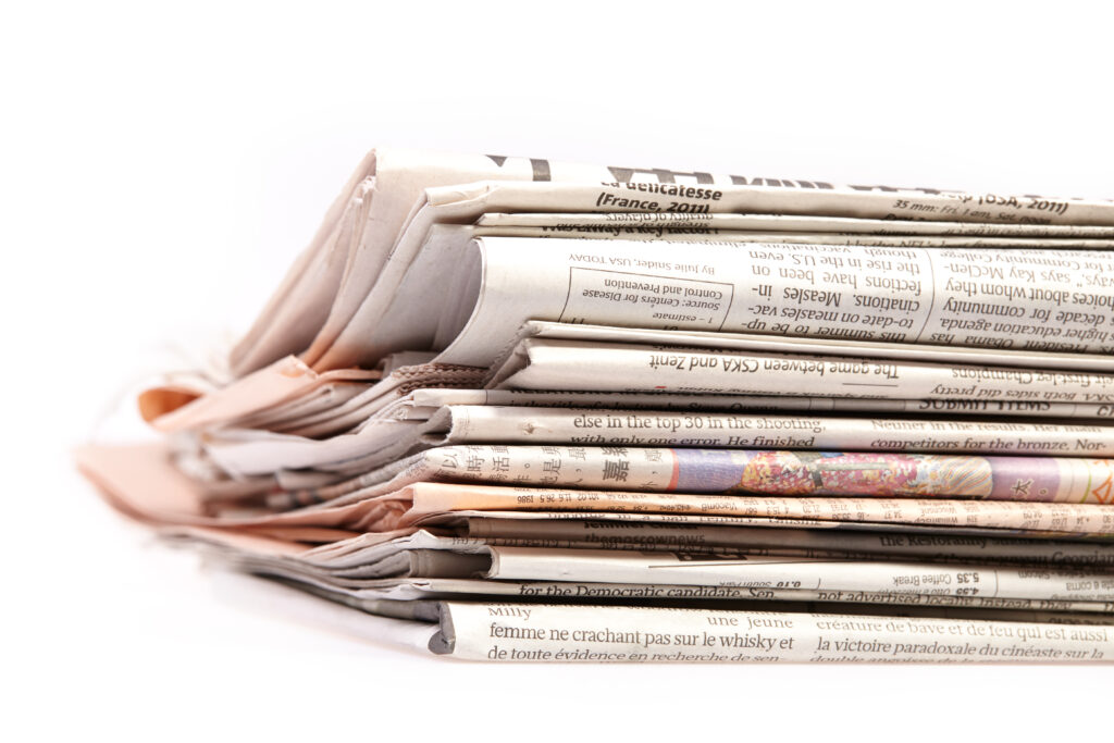 International newspapers on white background. Beautiful shallow dof.